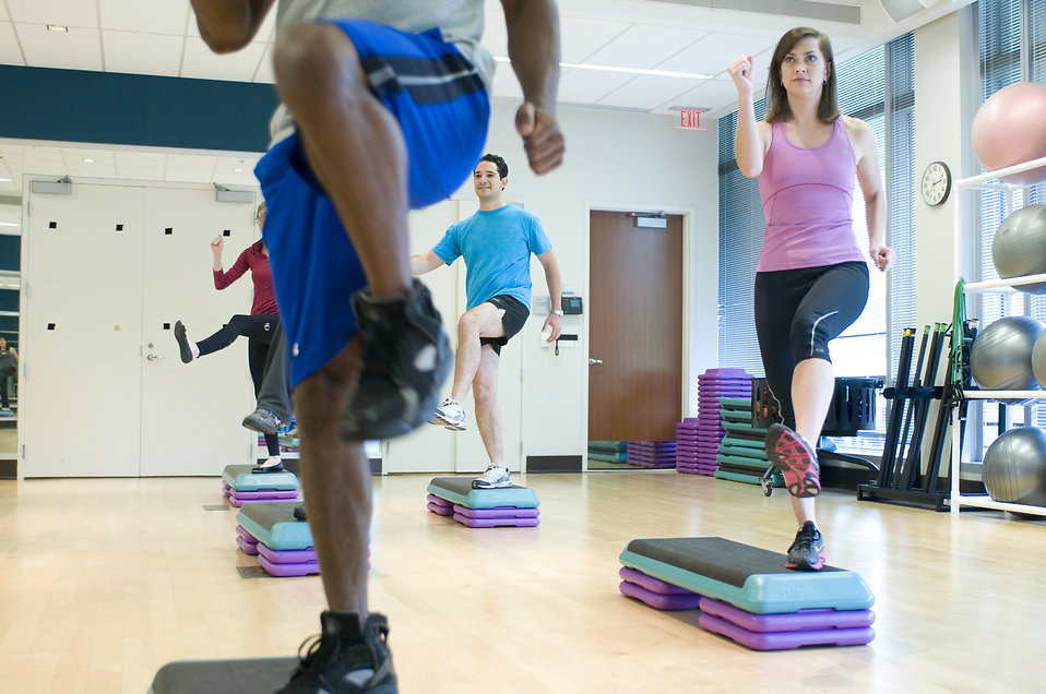 Men and women in an aerobics class in a gym.