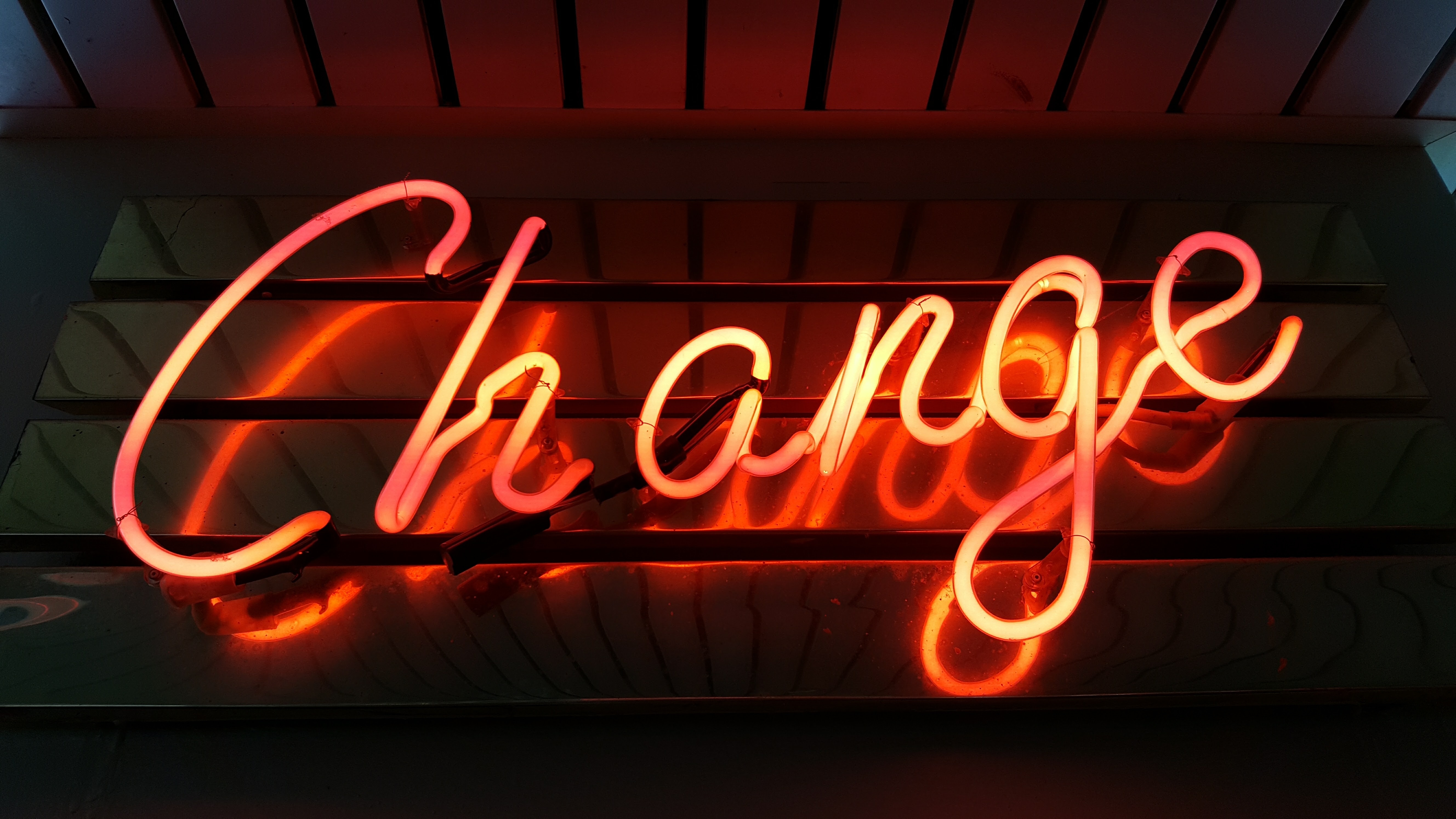A neon sign with the word change in cursive.