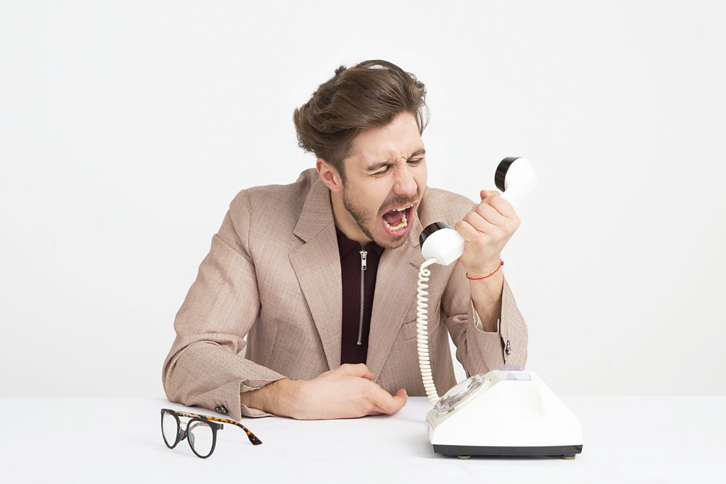 Photograph of a man yelling into a phone