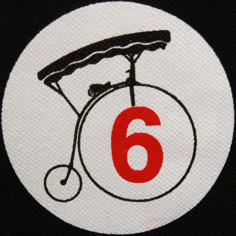 Image of an old bicycle with the large front wheel and the number 6 written in red text inside the wheel.