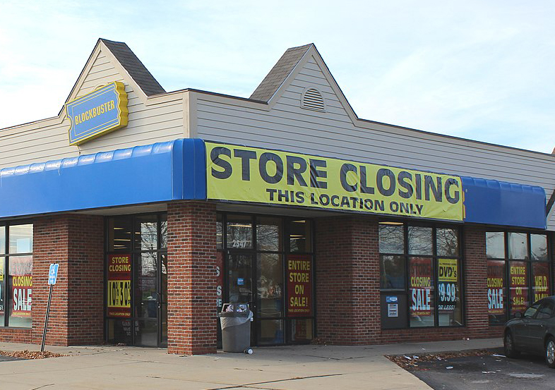 Front of a Blockbuster store with large sign saying 