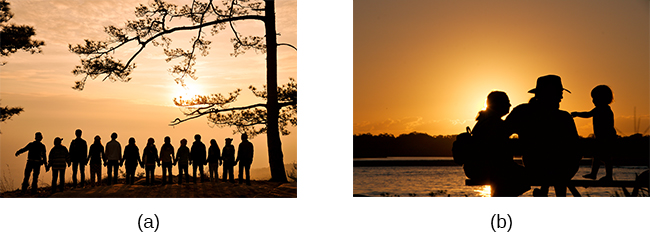 Photograph A shows a large group of people holding hands with the sun setting in the distance. Photograph B shows a close relationship between three people by the water.
