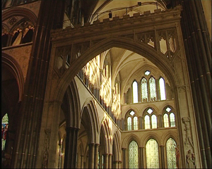 The ceiling is vaulted and the boundary of the transept is framed with an archway. The exterior wall has several stained glass windows.
