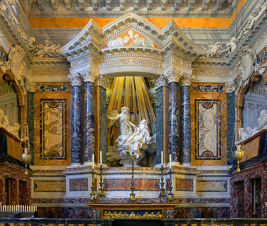 The focus of this work is a sculpture of an angel appearing to Saint Teresa with golden beams descending from the ceiling behind the two figures. The entirety of the walls, however, are a part of the work as well. Corinthian columns frame the sculpture and the walls are made of exquisite marble. We can see two alcoves with carved viewers on either side of the Ecstasy. 